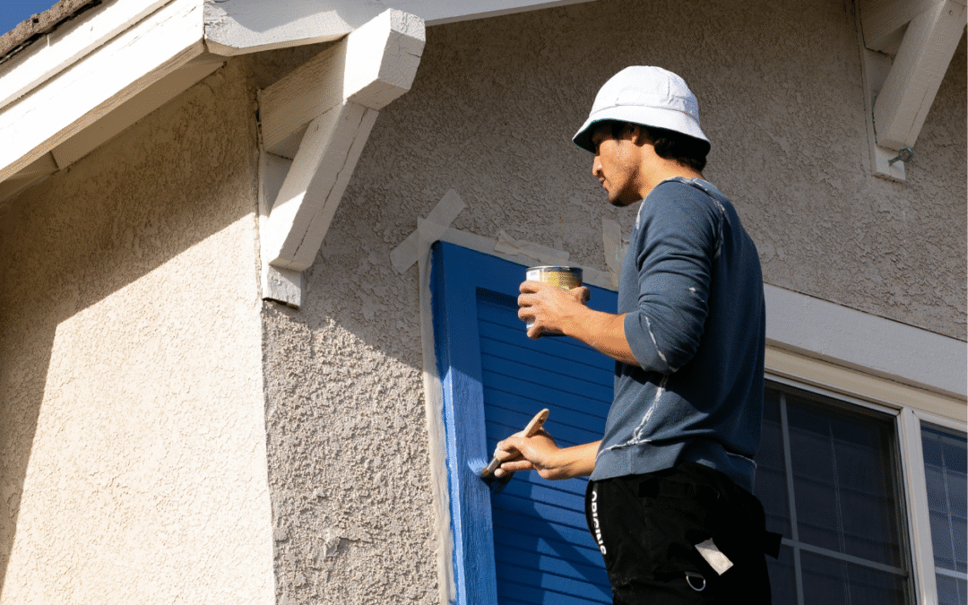 Man painting an outside window trim