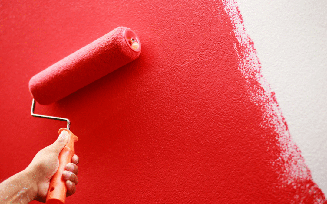 Someone painting a wall with red paint