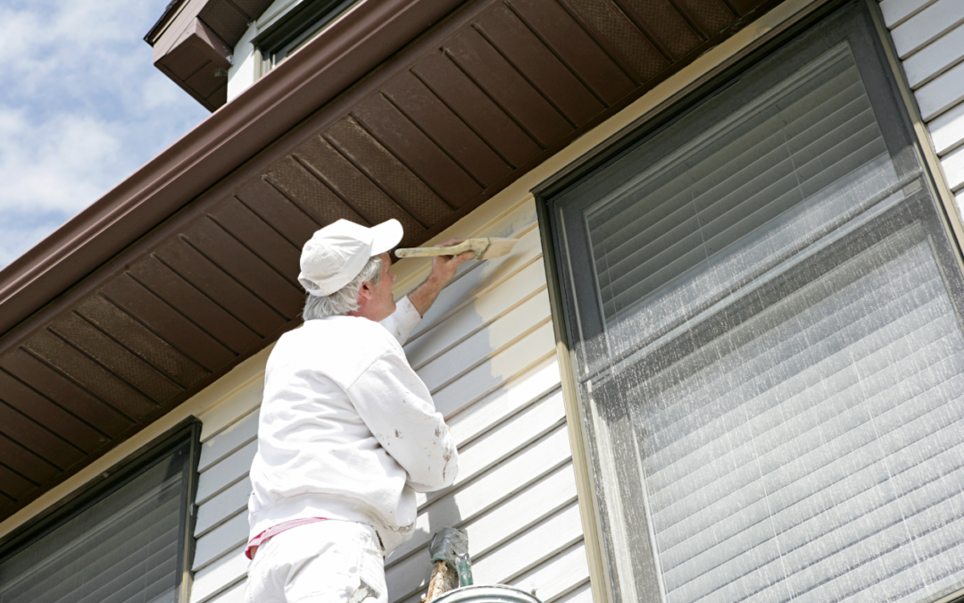A man painting the outside of a house